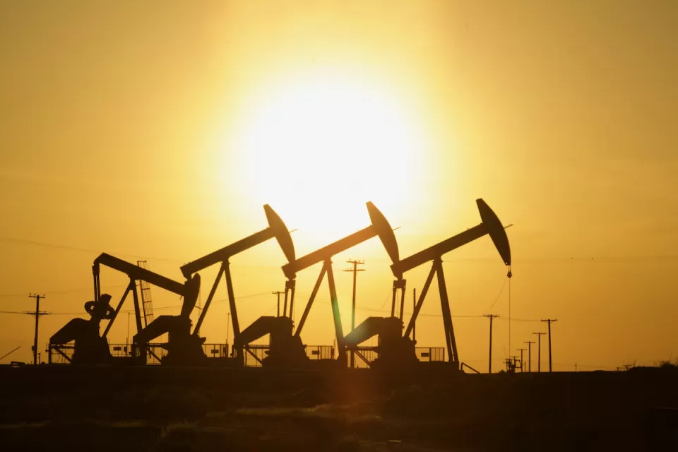 Four oil wells sillhouetted against the sunset.